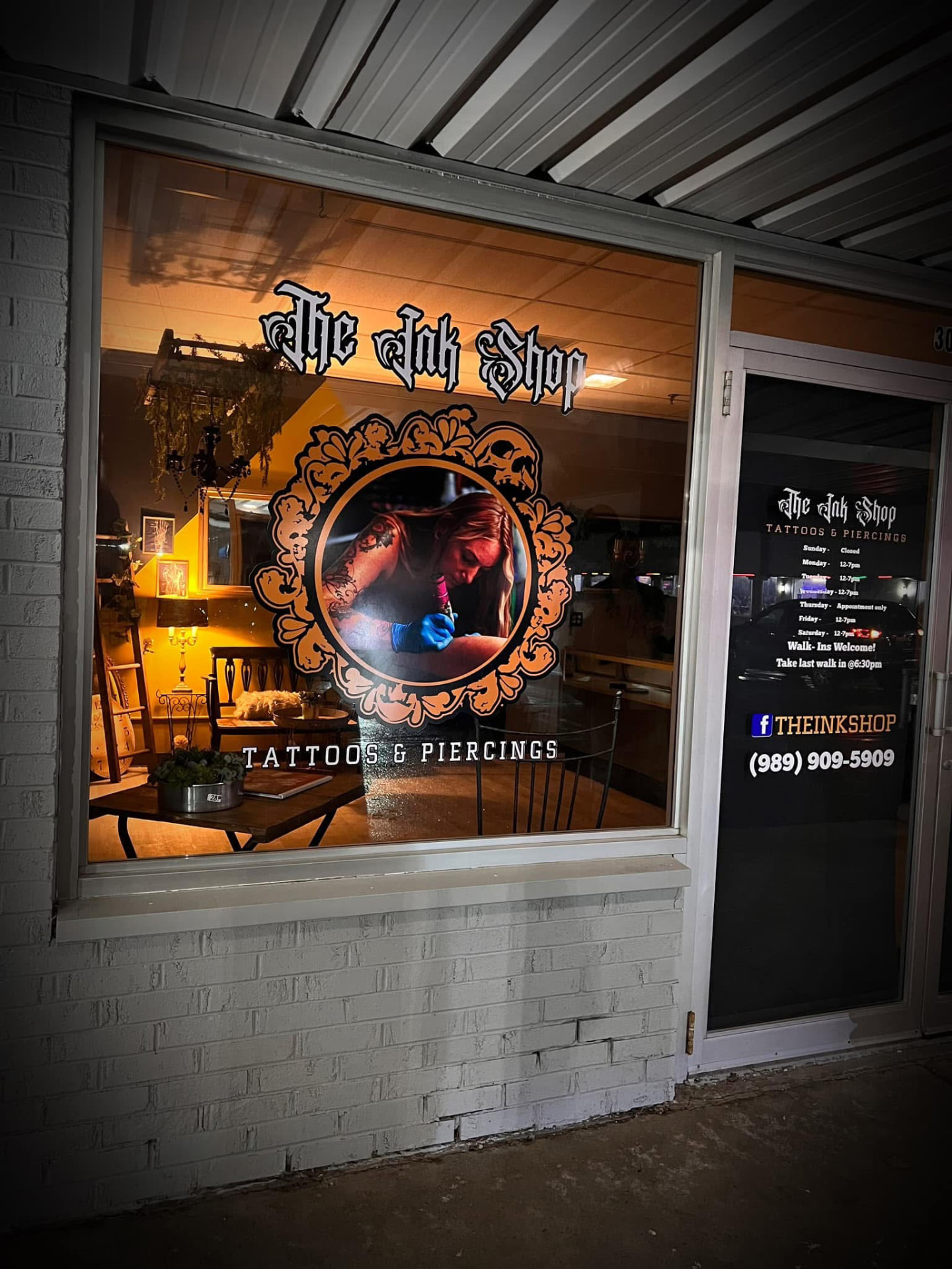 The Ink Shop storefront lit up at night in Saginaw, Michigan