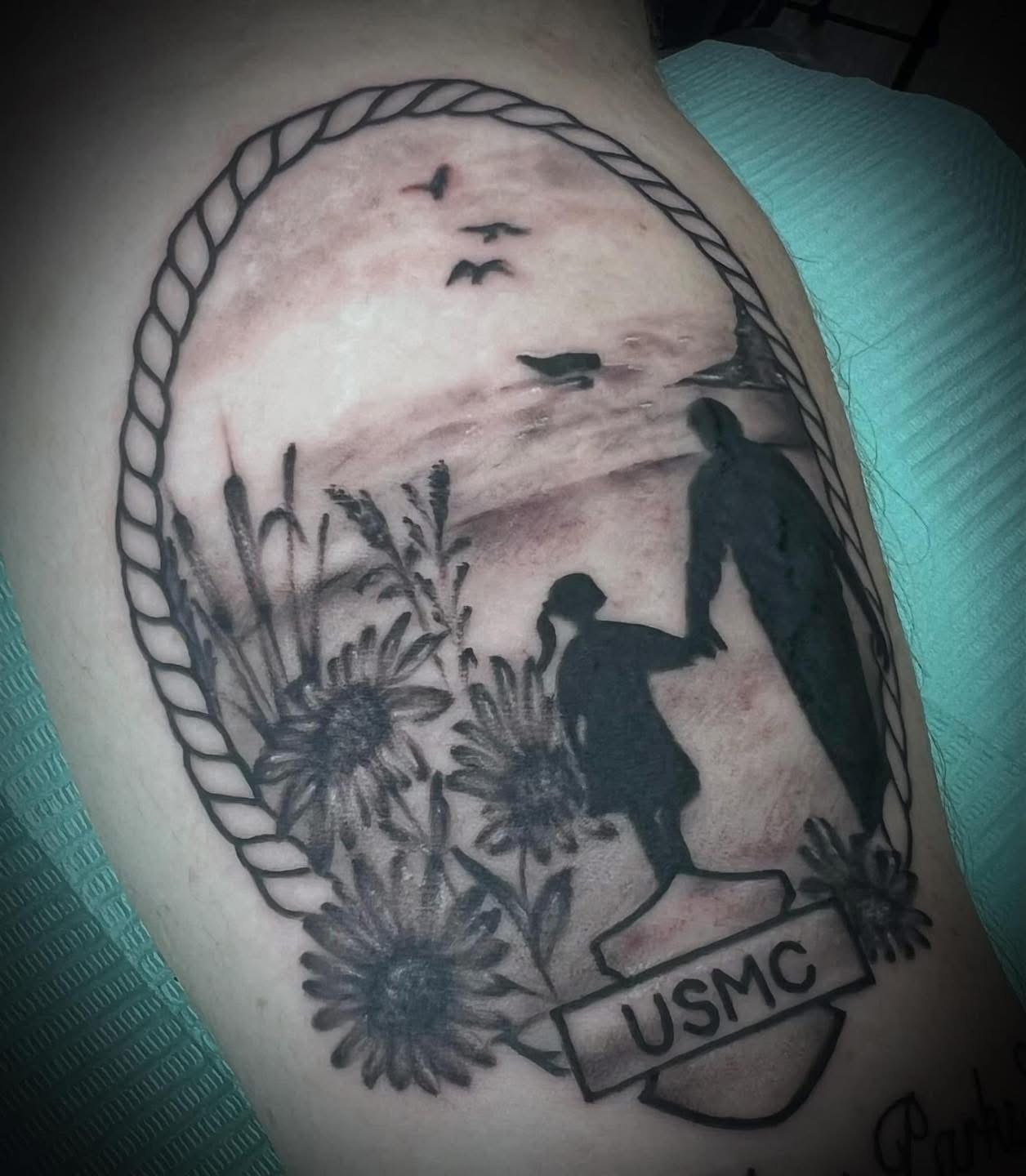 Black and grey USMC memorial tattoo with a beach scene and sunflowers