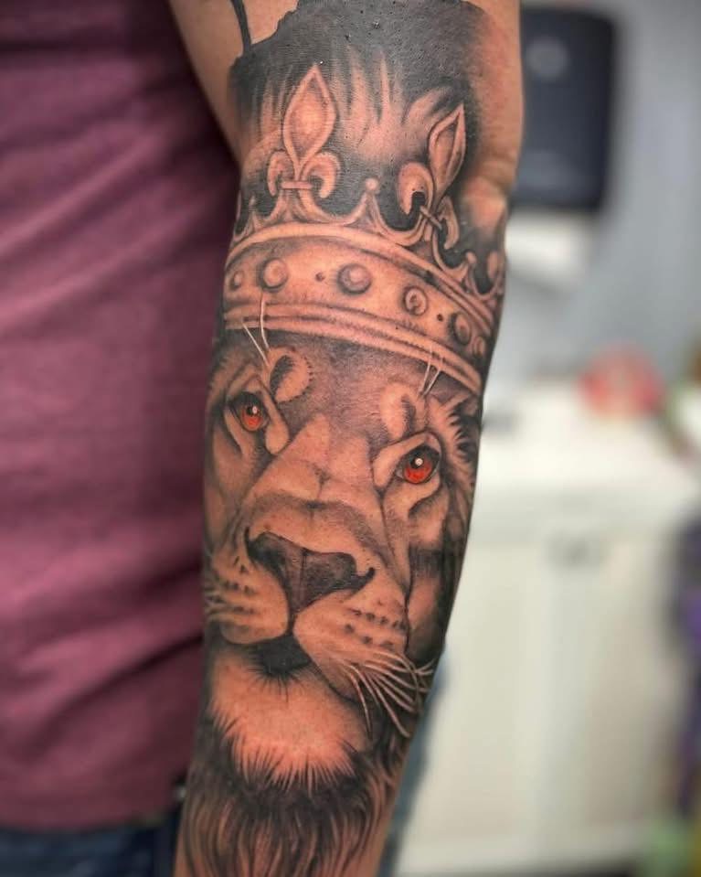 Black and grey lion with a crown, half sleeve on a forearm