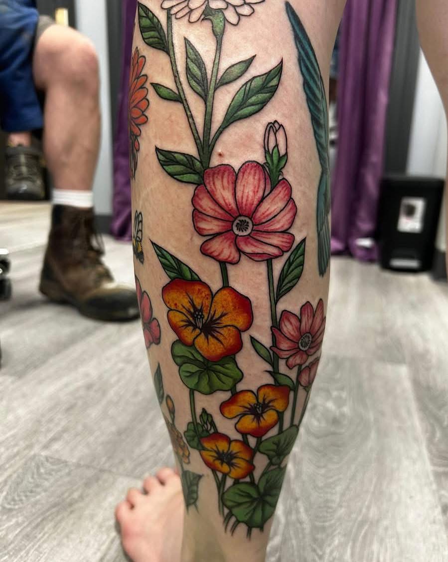 Color wildflower garden tattoo covering a lower leg