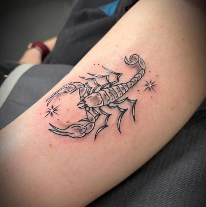 Fine-line scorpion tattoo with sparkles on an arm