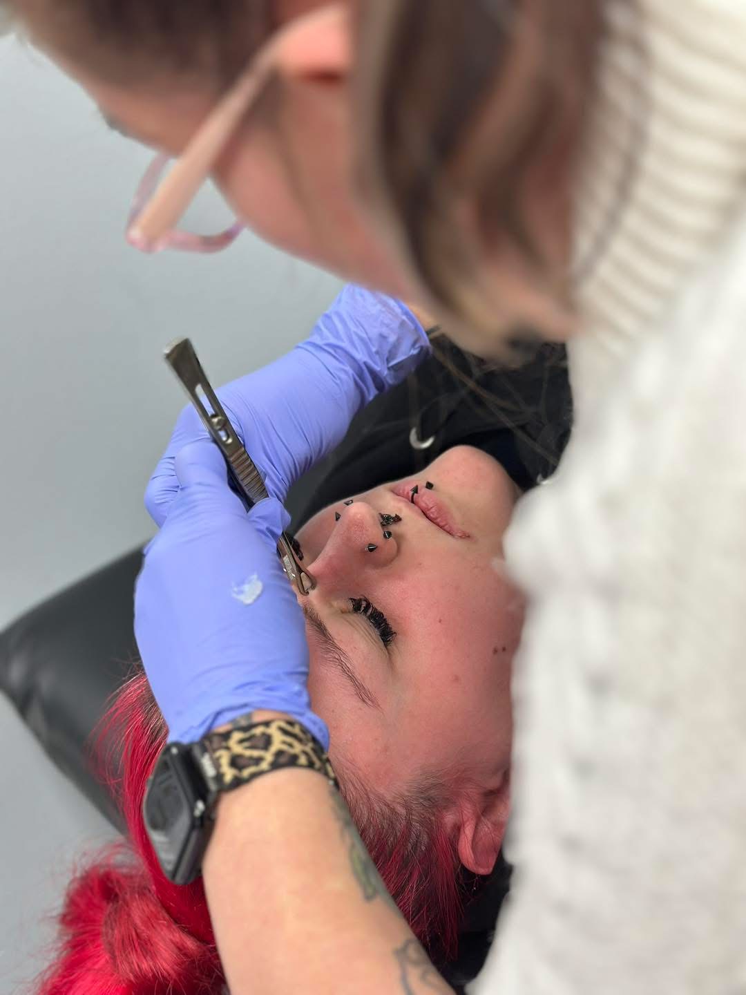 Piercer at work on a client in the studio