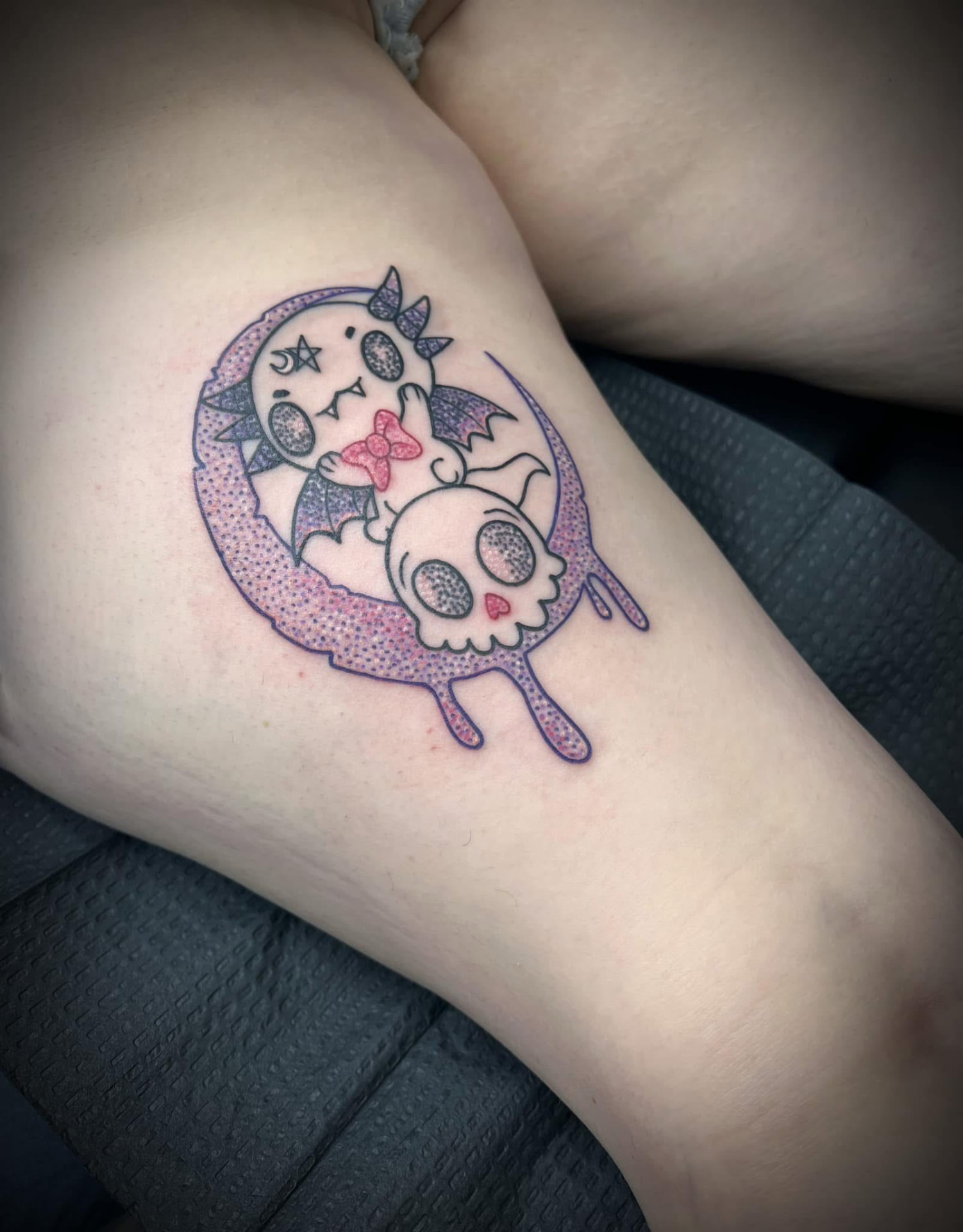 Pastel kawaii moon and skull tattoo on a thigh