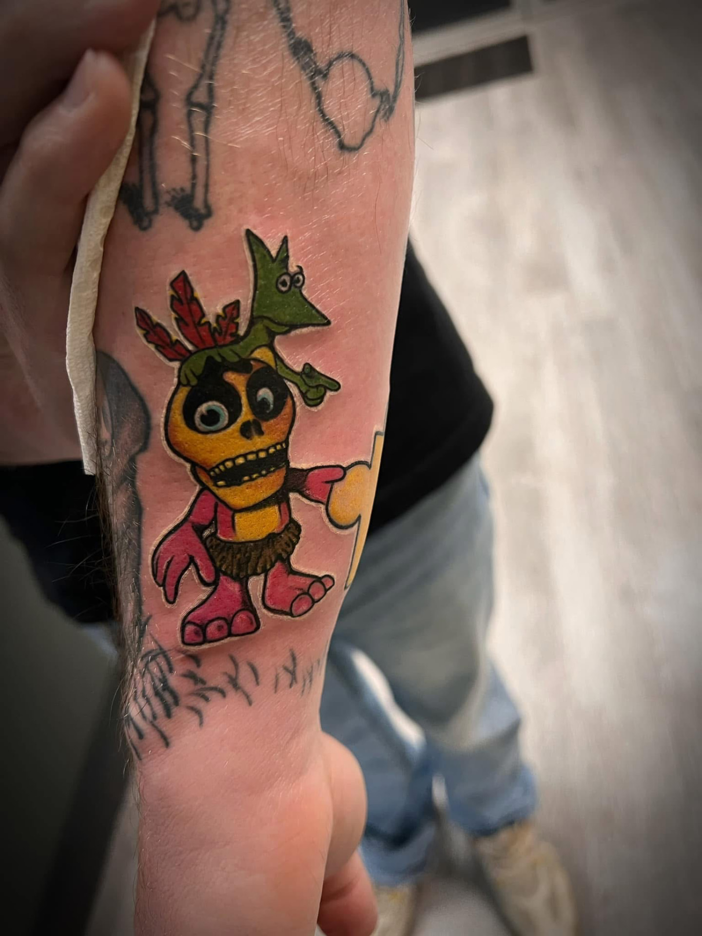 Bright cartoon character tattoo on a forearm
